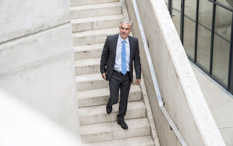 Ein Mann im Anzug auf einer Treppe.